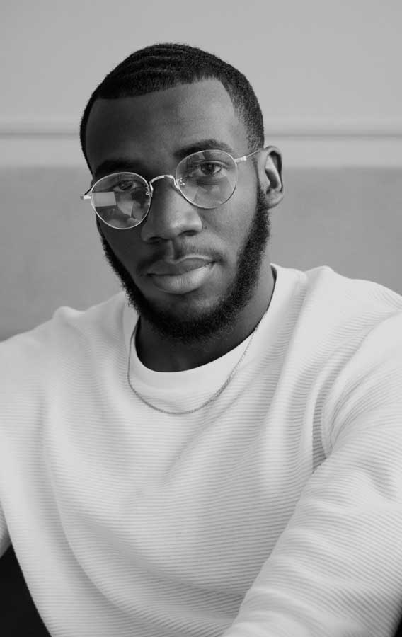 Man with glasses and beard in portrait.
