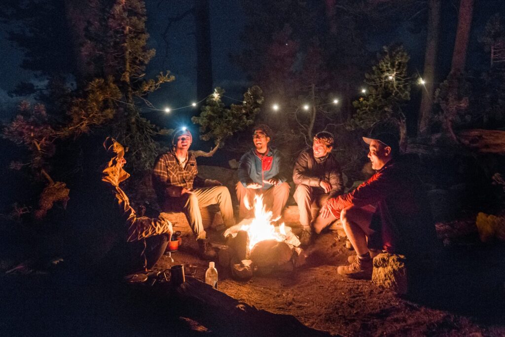 Group of friends gathered around a campfire.